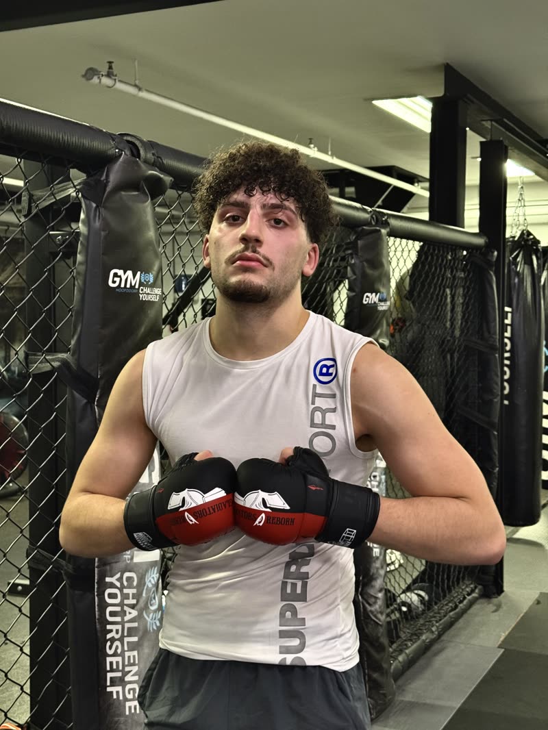 Fighter by the cage with the Red/Black Edition at chest height